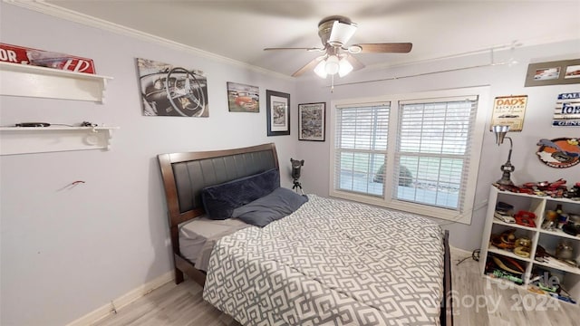 bedroom featuring ceiling fan, light wood-type flooring, and crown molding