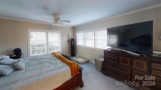 carpeted bedroom featuring ceiling fan and crown molding