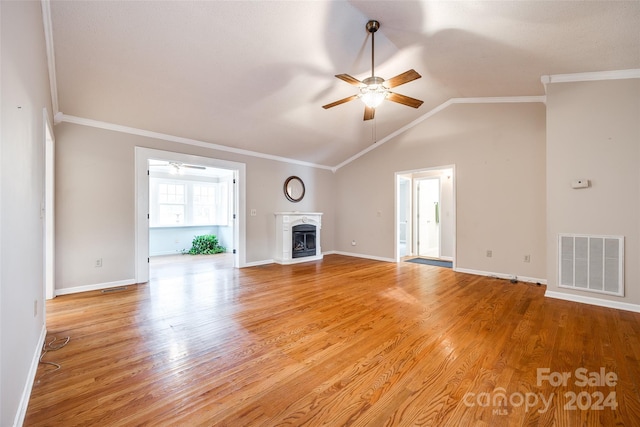 unfurnished living room with ceiling fan, light wood-type flooring, crown molding, and vaulted ceiling