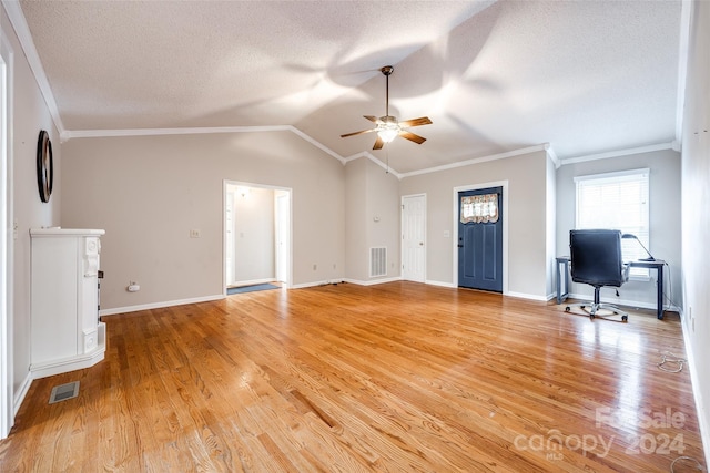 unfurnished living room with a textured ceiling, vaulted ceiling, light hardwood / wood-style flooring, and crown molding