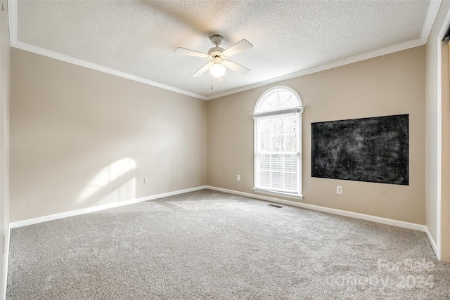 carpeted empty room featuring ceiling fan, a textured ceiling, and ornamental molding