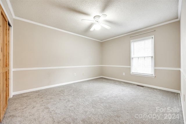 carpeted empty room featuring a textured ceiling, ceiling fan, and ornamental molding