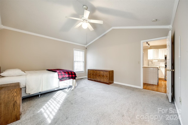 carpeted bedroom with ornamental molding, vaulted ceiling, ceiling fan, sink, and connected bathroom