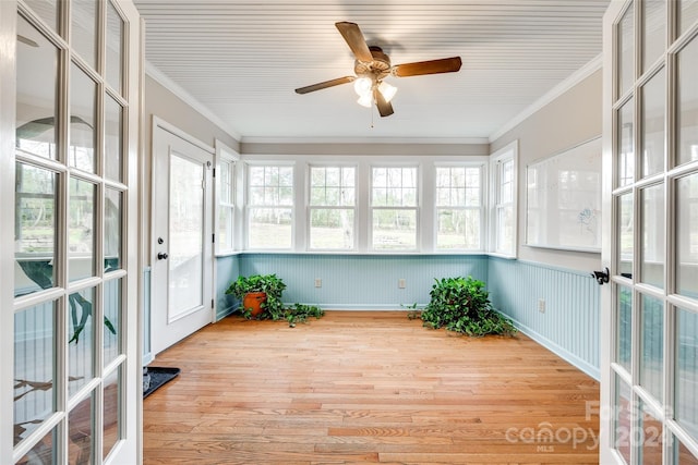 unfurnished sunroom featuring ceiling fan