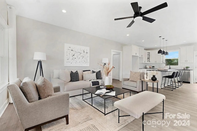 living room featuring light wood-type flooring and ceiling fan