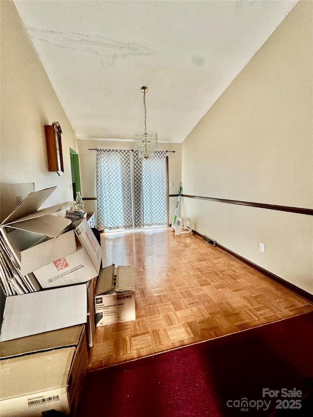 dining room featuring a notable chandelier, parquet flooring, and vaulted ceiling