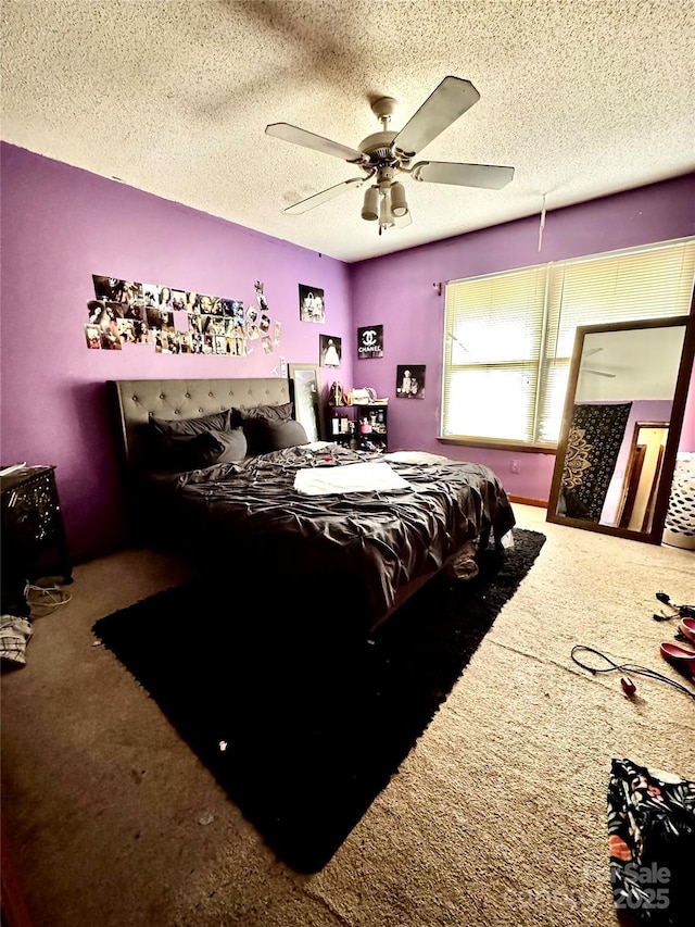 bedroom with a textured ceiling, carpet floors, and ceiling fan