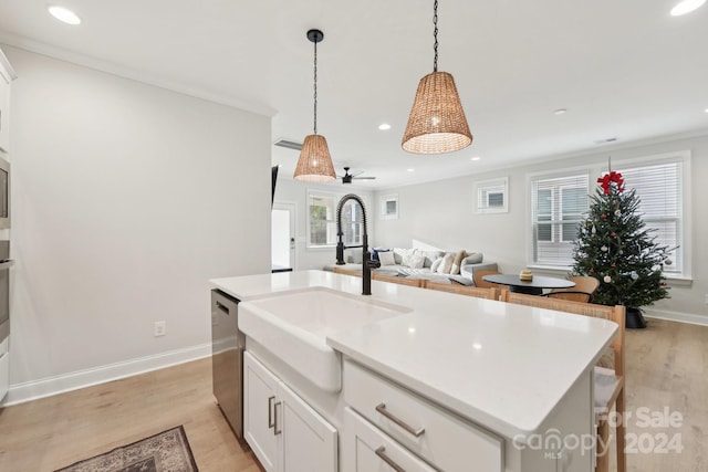 kitchen featuring a center island with sink, white cabinetry, sink, and light hardwood / wood-style flooring