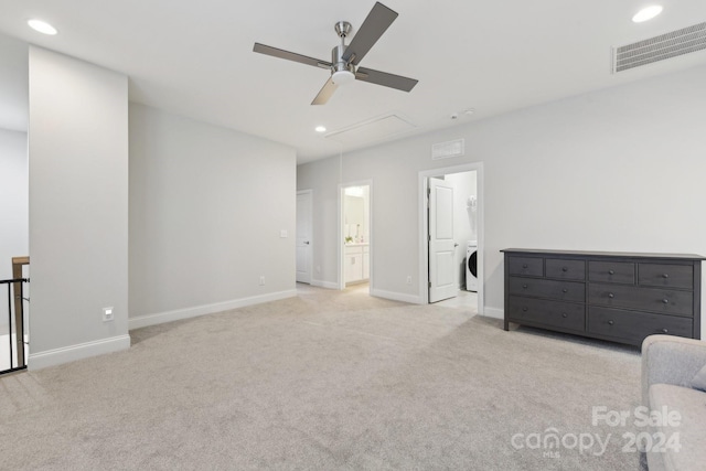 unfurnished bedroom featuring ceiling fan, washer / dryer, light carpet, and connected bathroom