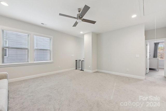 spare room featuring ceiling fan and light carpet