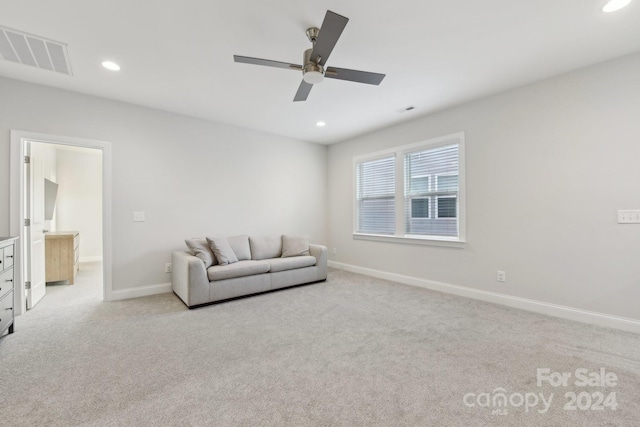 living area with light colored carpet and ceiling fan