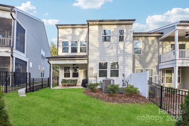 back of house featuring ceiling fan, a patio area, a yard, and central AC