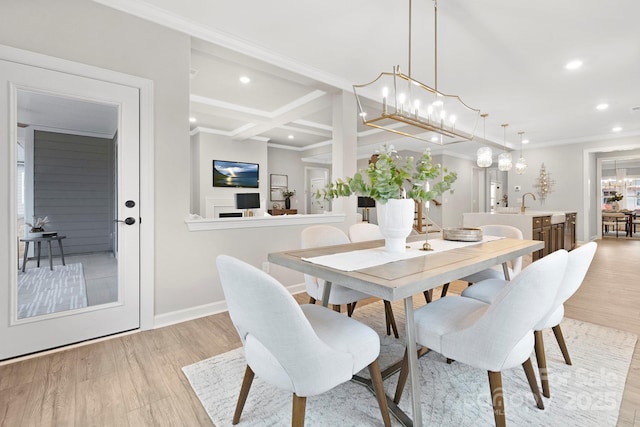 dining space featuring beamed ceiling, a chandelier, coffered ceiling, crown molding, and light hardwood / wood-style flooring