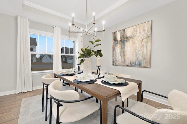 dining area featuring crown molding, hardwood / wood-style flooring, and a raised ceiling