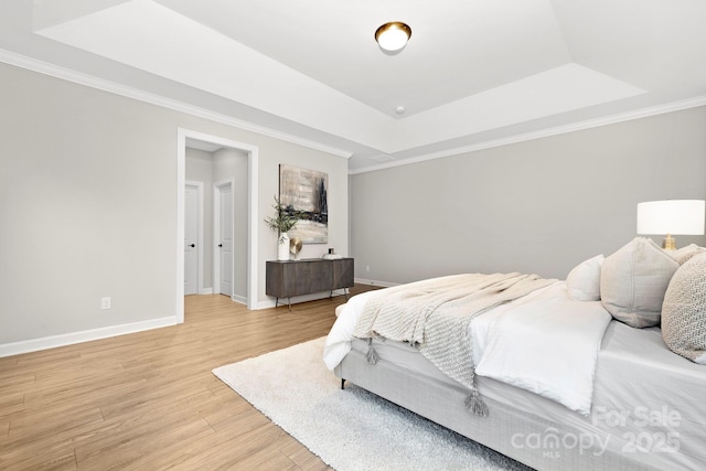 bedroom featuring crown molding, a tray ceiling, and hardwood / wood-style floors