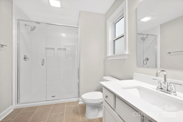 bathroom with vanity, a shower with shower door, tile patterned floors, and toilet