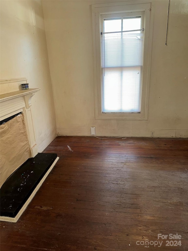 unfurnished living room featuring dark hardwood / wood-style flooring and a wealth of natural light