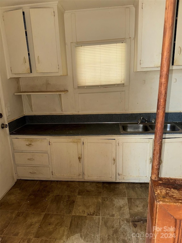 kitchen featuring white cabinetry and sink