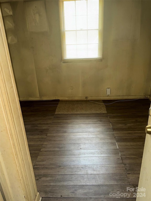 unfurnished room with dark wood-type flooring