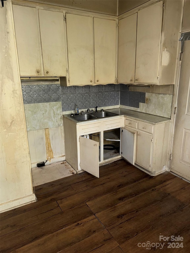 kitchen featuring tasteful backsplash, sink, dark wood-type flooring, and cream cabinetry