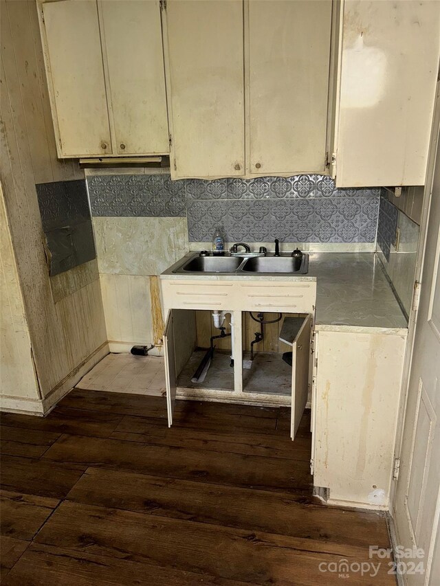 kitchen with tasteful backsplash, cream cabinets, dark hardwood / wood-style flooring, and sink