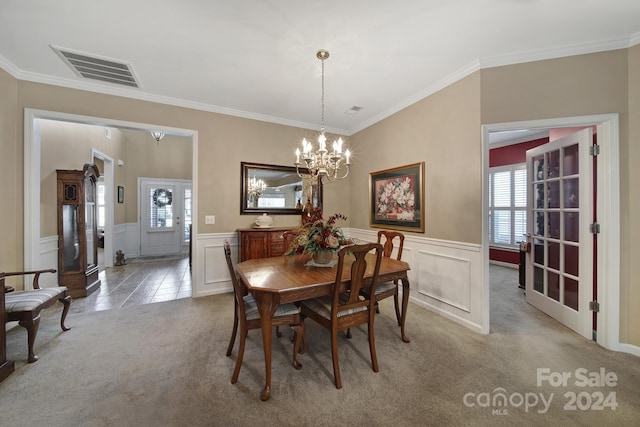 dining room featuring carpet flooring, a notable chandelier, and ornamental molding