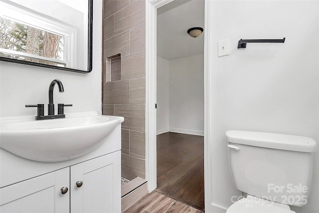 bathroom featuring toilet, hardwood / wood-style flooring, and vanity