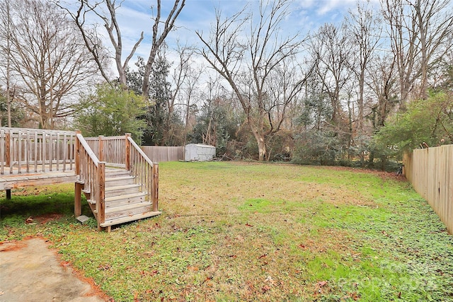 view of yard featuring a wooden deck and a storage unit