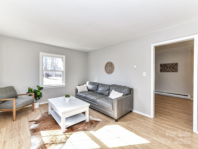 living room with a baseboard heating unit and light hardwood / wood-style floors