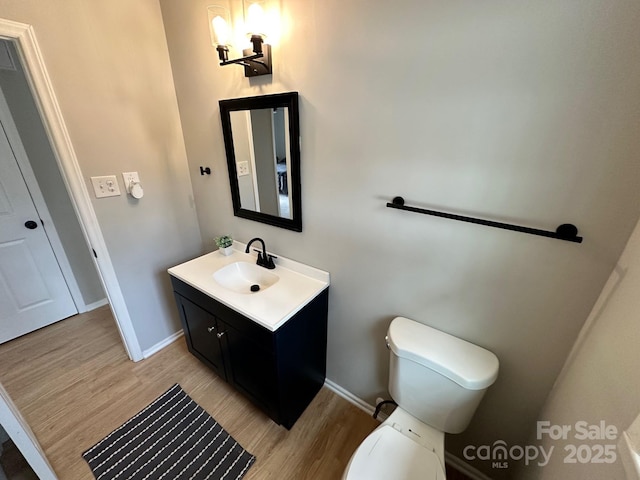 bathroom featuring vanity, wood-type flooring, and toilet