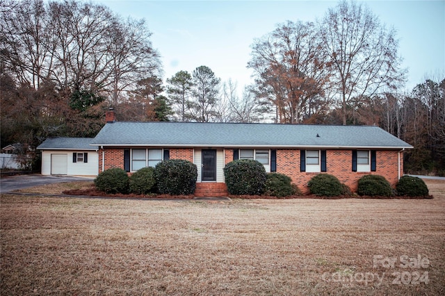 ranch-style home featuring a front lawn and a garage