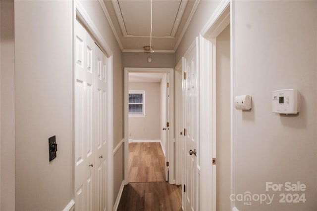 corridor featuring wood-type flooring and ornamental molding