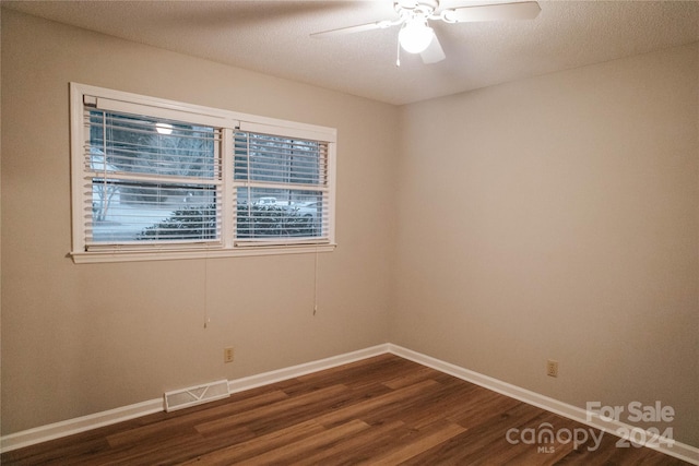 unfurnished room featuring ceiling fan, dark hardwood / wood-style flooring, and a textured ceiling