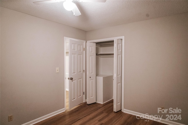 unfurnished bedroom with a textured ceiling, dark hardwood / wood-style flooring, a closet, and ceiling fan