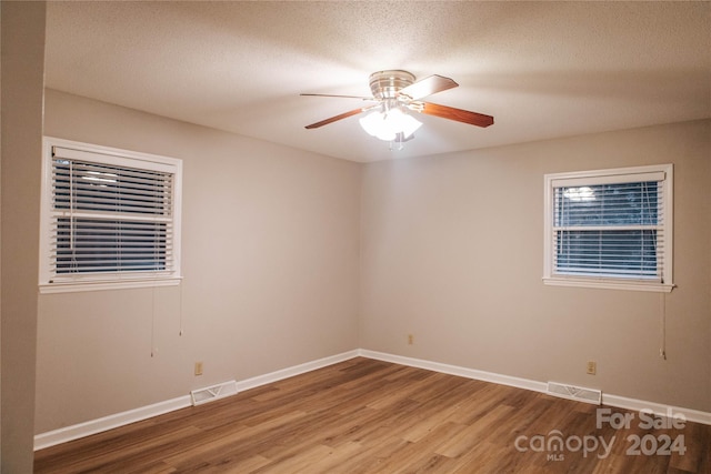 empty room with wood-type flooring, a textured ceiling, and ceiling fan