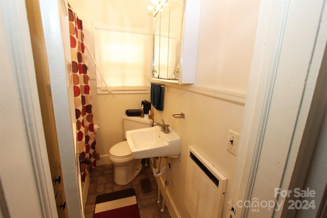 bathroom with sink, a shower with shower curtain, toilet, tile walls, and heating unit