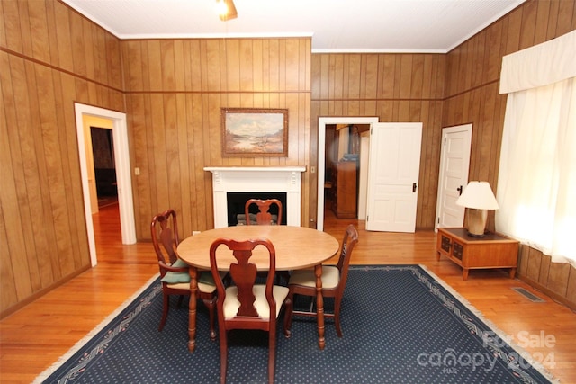 dining area with light hardwood / wood-style floors and ornamental molding