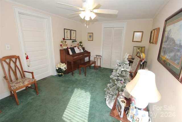 sitting room featuring dark carpet, ceiling fan, and crown molding