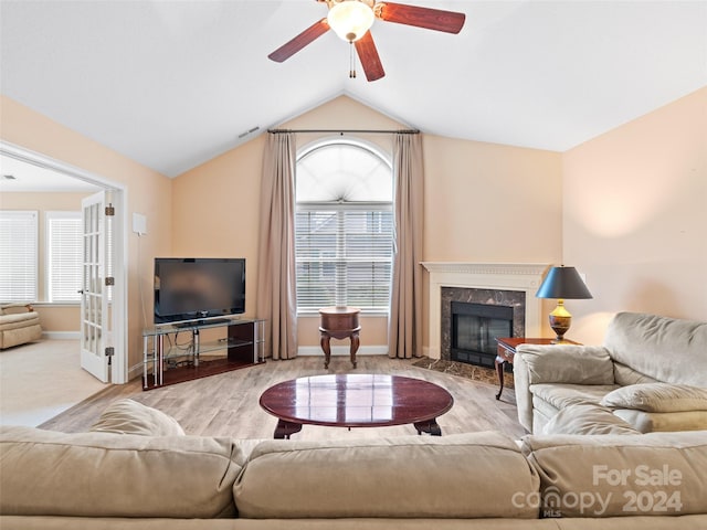 living room with a premium fireplace, plenty of natural light, light hardwood / wood-style floors, and lofted ceiling