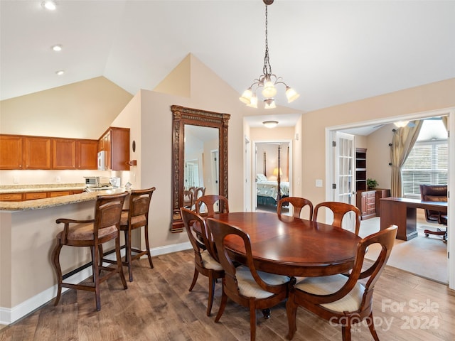 dining area with vaulted ceiling, dark wood-type flooring, and a notable chandelier