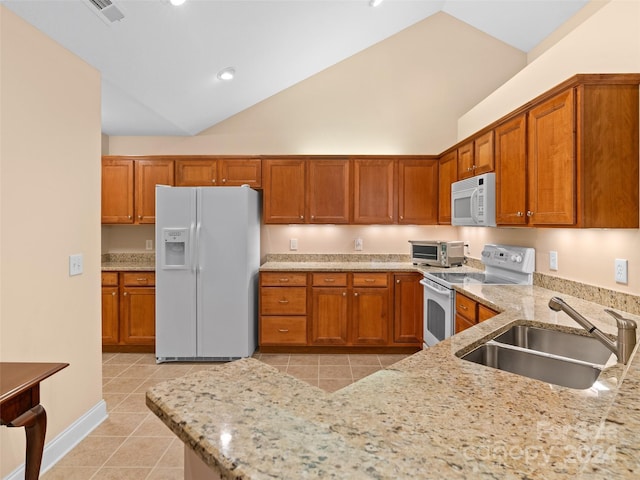 kitchen with light stone counters, white appliances, sink, light tile patterned floors, and high vaulted ceiling