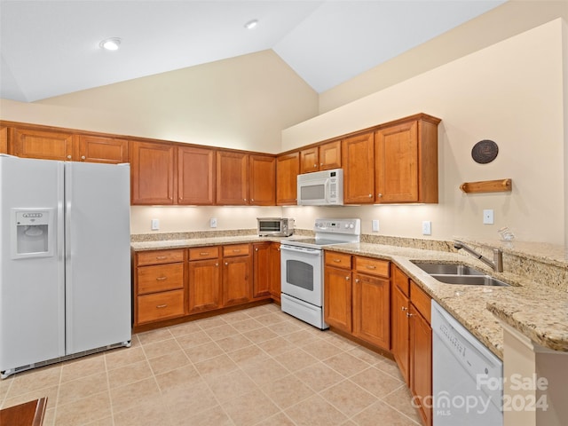 kitchen with light stone countertops, white appliances, sink, and high vaulted ceiling