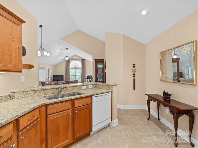 kitchen featuring white dishwasher, light stone counters, lofted ceiling, and sink