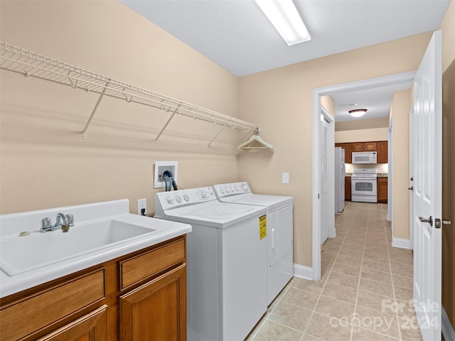 washroom with washer and dryer, cabinets, and sink