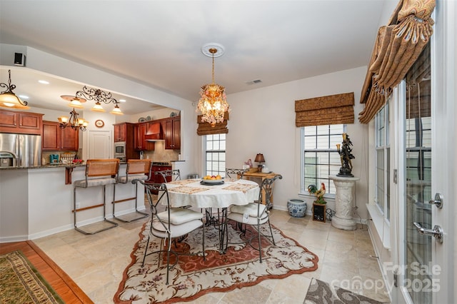 dining space with plenty of natural light and an inviting chandelier