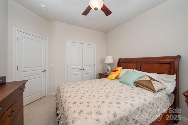 bedroom with ceiling fan, light colored carpet, and a closet