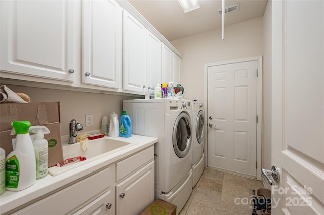 laundry area featuring sink, cabinets, and washing machine and clothes dryer