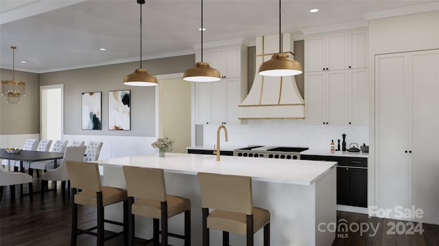 kitchen with a kitchen island with sink, hanging light fixtures, dark hardwood / wood-style floors, white cabinetry, and a breakfast bar area