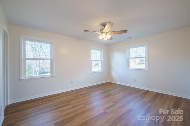 unfurnished room featuring ceiling fan, a healthy amount of sunlight, and dark hardwood / wood-style flooring