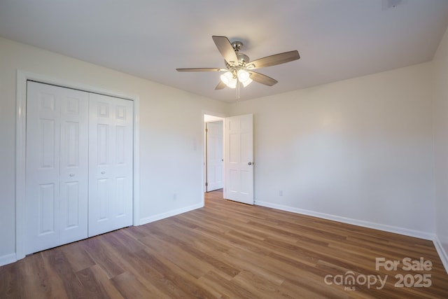 unfurnished bedroom featuring a closet, ceiling fan, and hardwood / wood-style flooring